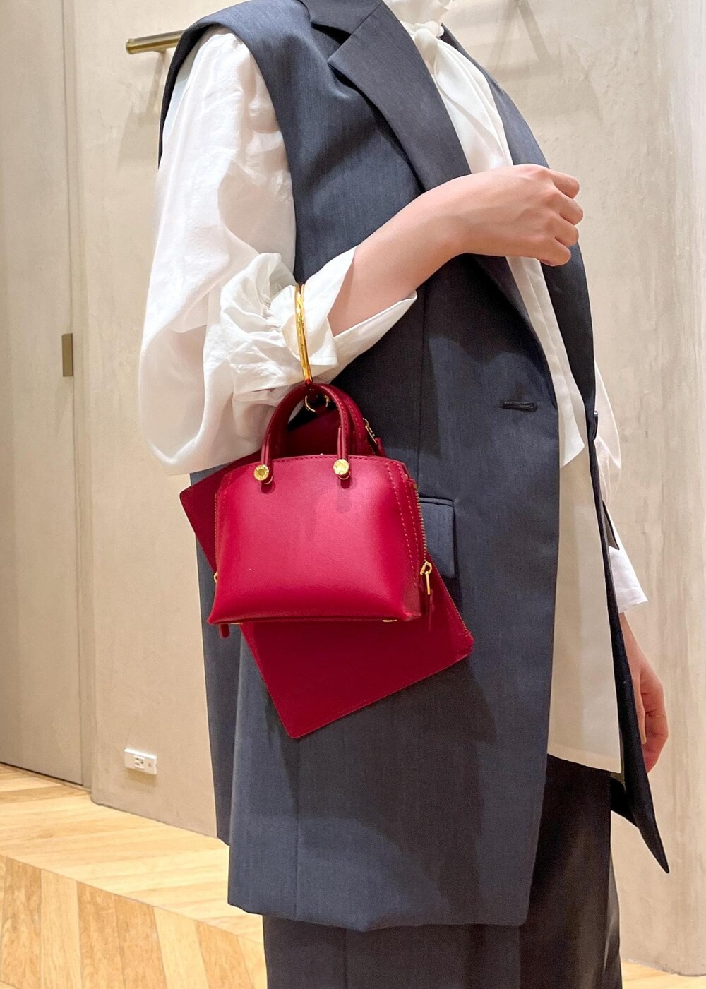 レッド系のパンプス、グレー系のベスト、グレー系のその他パンツを着用したレディースの秋コーディネートの8枚目の写真