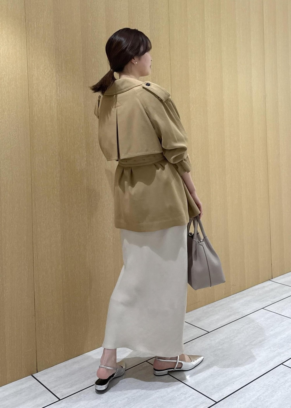 ベージュ系のトレンチコート、ベージュ系のスカート、ピンク系のシャツ/ブラウスを着用したレディースの春コーディネートの3枚目の写真