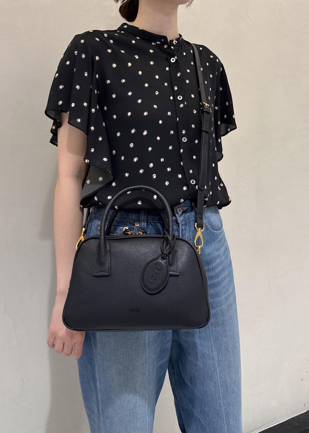 ブルー系のデニムパンツ、ブラック系のシャツ/ブラウス、ブラック系のハンドバッグを着用したレディースの夏コーディネートの8枚目の写真