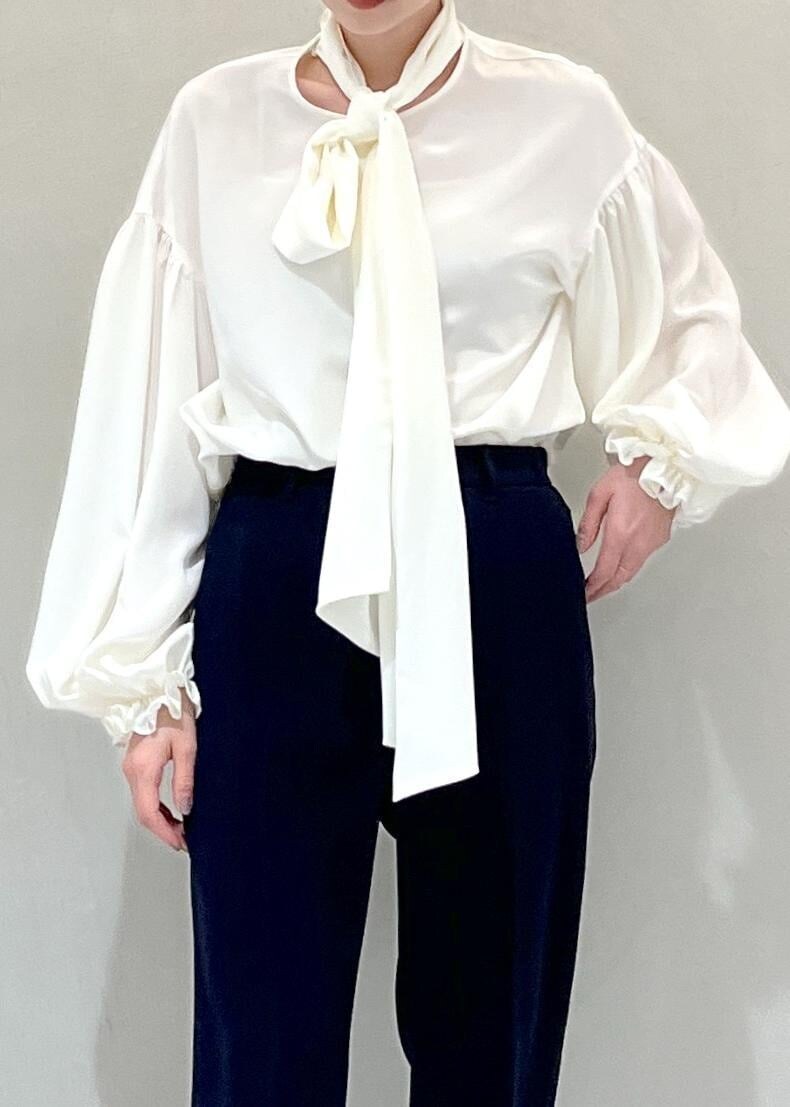 ブラック系のパンプス、ブラック系のハンドバッグ、ホワイト系のシャツ/ブラウスを着用したレディースの冬コーディネートの4枚目の写真