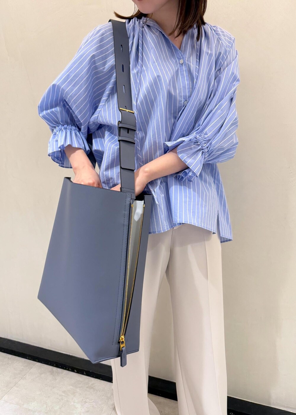 ベージュ系のその他パンツ、ブルー系のショルダーバッグ、ブルー系のシャツ/ブラウスを着用したレディースの春コーディネートの8枚目の写真
