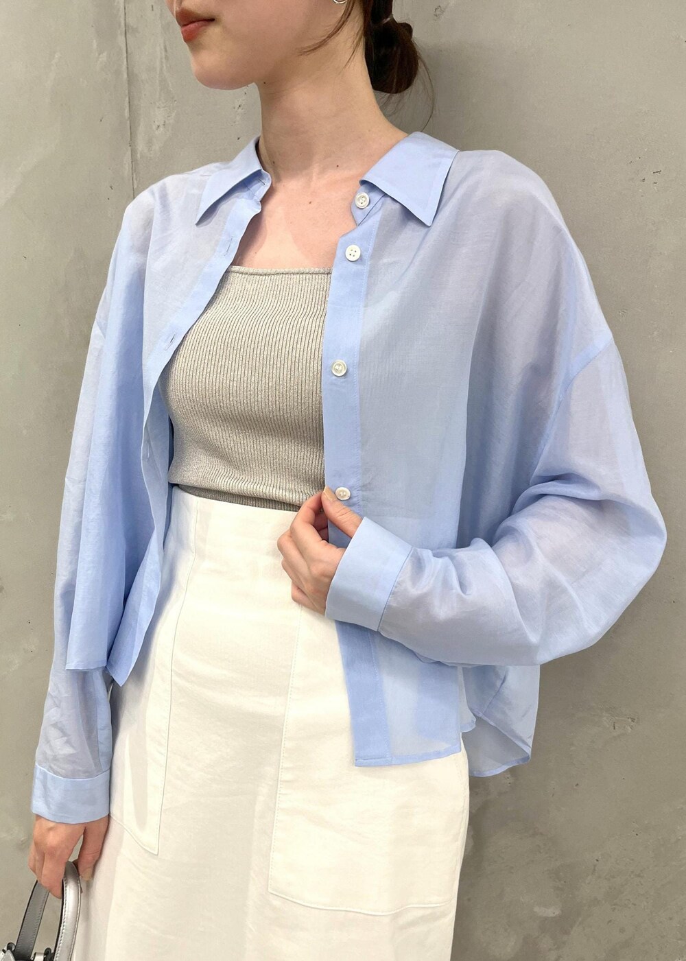 シルバー系のサンダル、ホワイト系のスカート、シルバー系のハンドバッグを着用したレディースの夏コーディネートの4枚目の写真