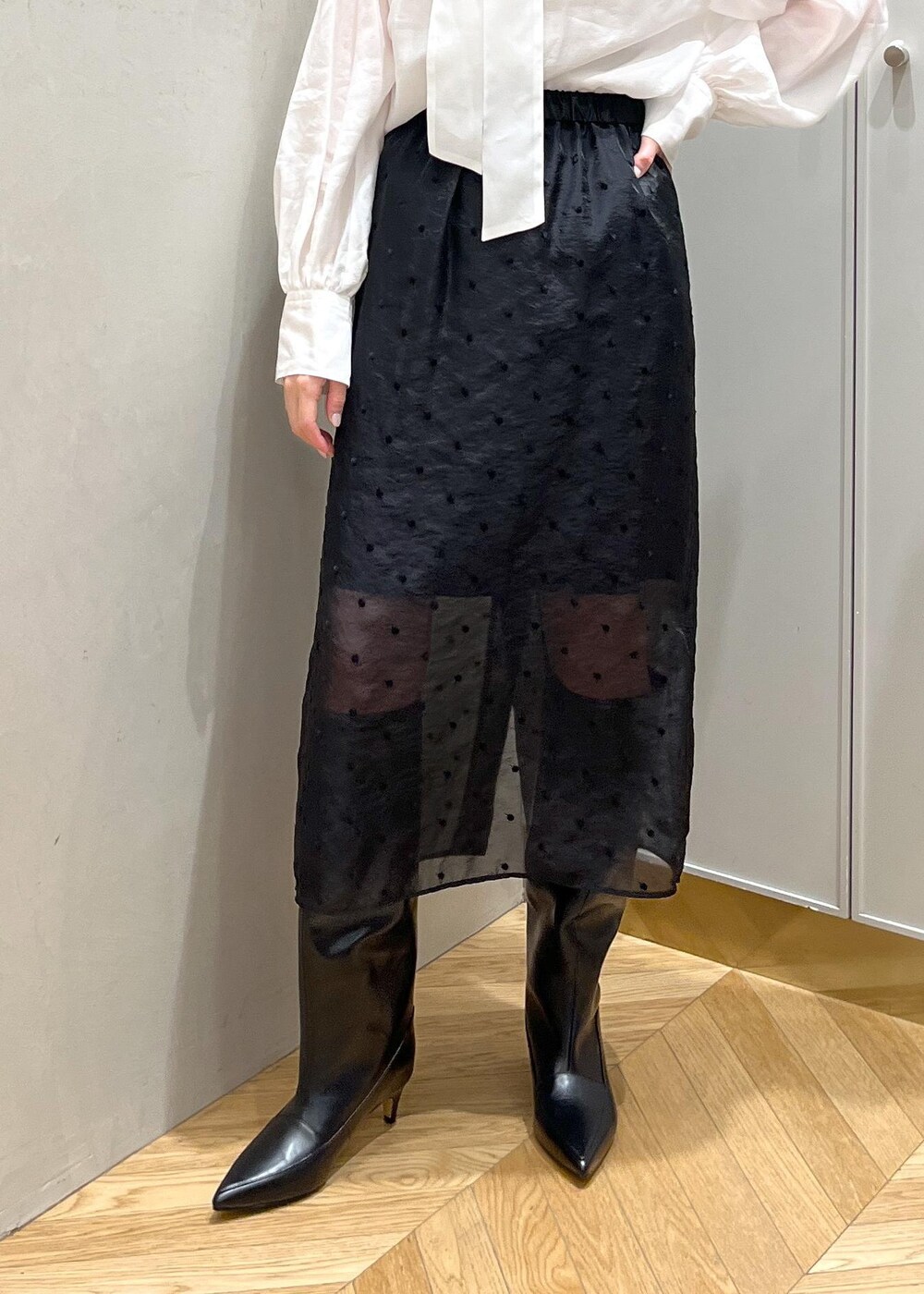 ブラック系のブーツ、ホワイト系のシャツ/ブラウス、グレー系のカーディガン/ボレロを着用したレディースの秋コーディネートの7枚目の写真