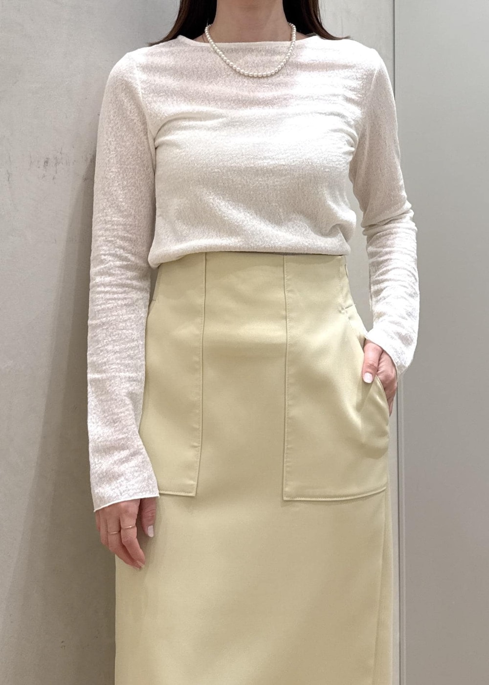ベージュ系のショルダーバッグ、イエロー系のスカート、ブルー系のデニムジャケットを着用したレディースの春コーディネートの6枚目の写真