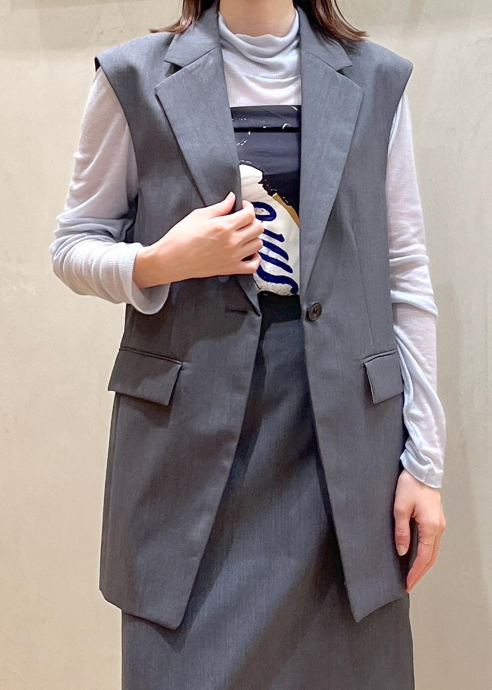 ブラック系のブーツ、ブルー系のショルダーバッグ、グレー系のベストを着用したレディースの秋コーディネートの3枚目の写真