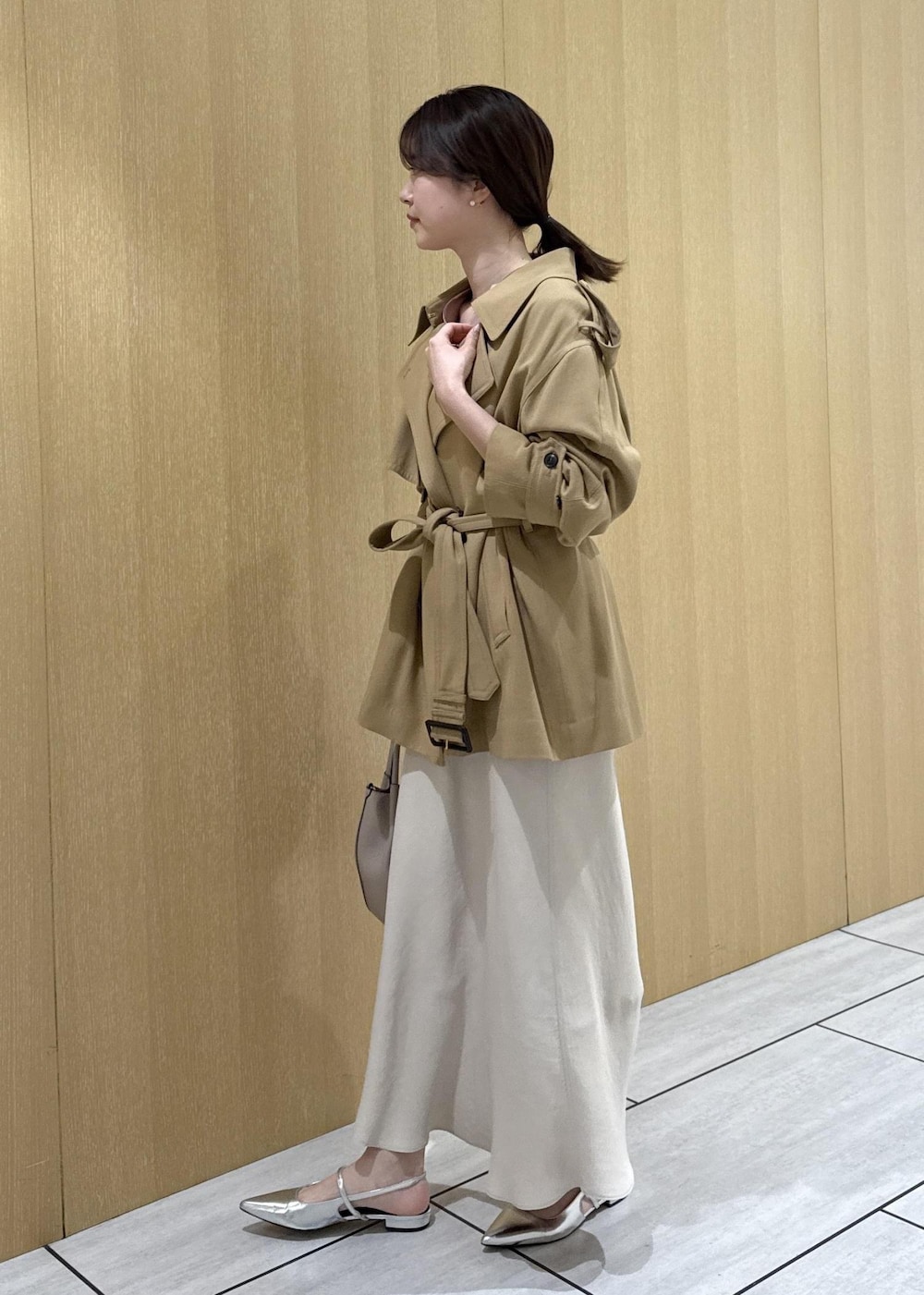 ベージュ系のトレンチコート、ベージュ系のスカート、ピンク系のシャツ/ブラウスを着用したレディースの春コーディネートの2枚目の写真