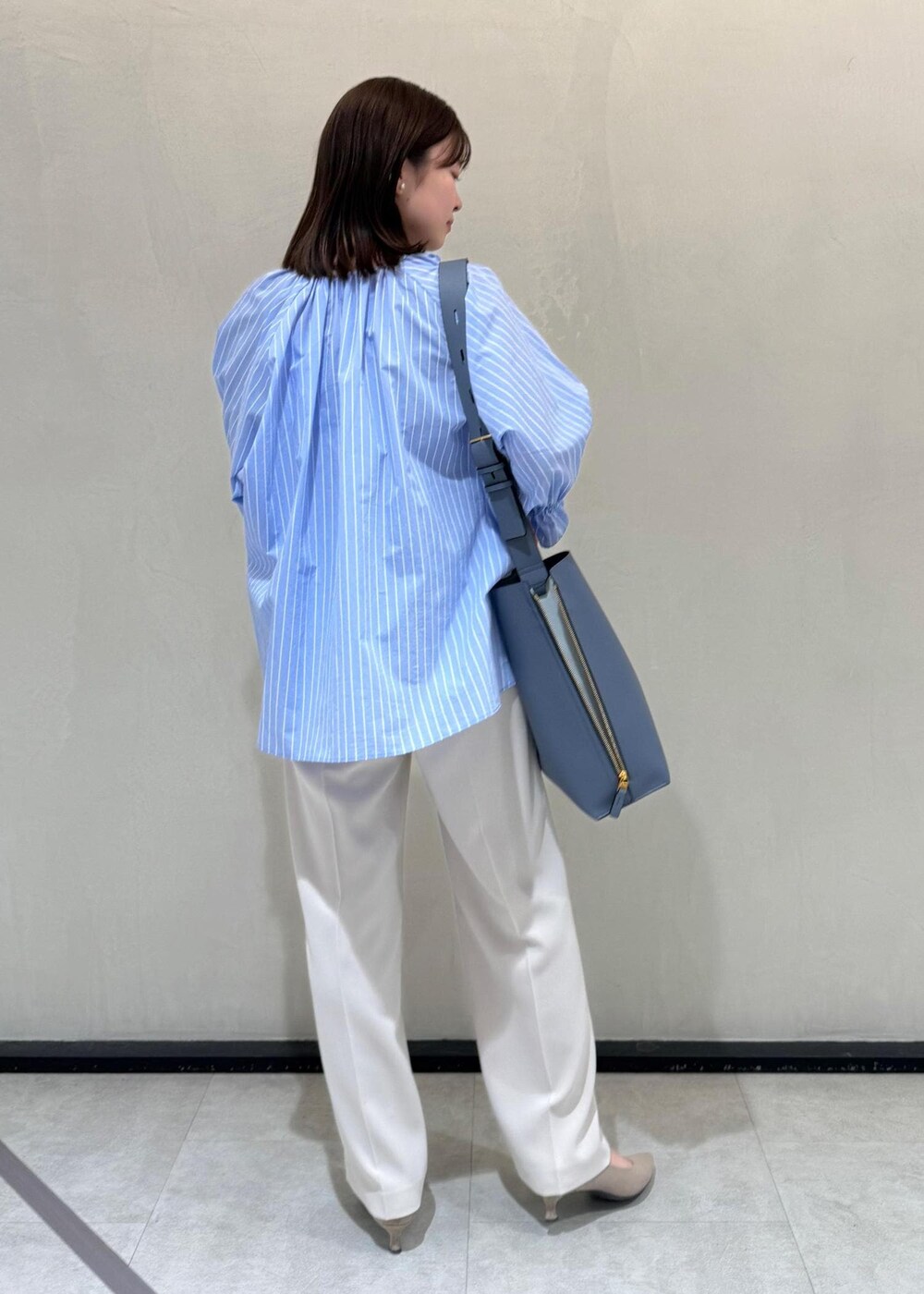 ベージュ系のその他パンツ、ブルー系のショルダーバッグ、ブルー系のシャツ/ブラウスを着用したレディースの春コーディネートの3枚目の写真