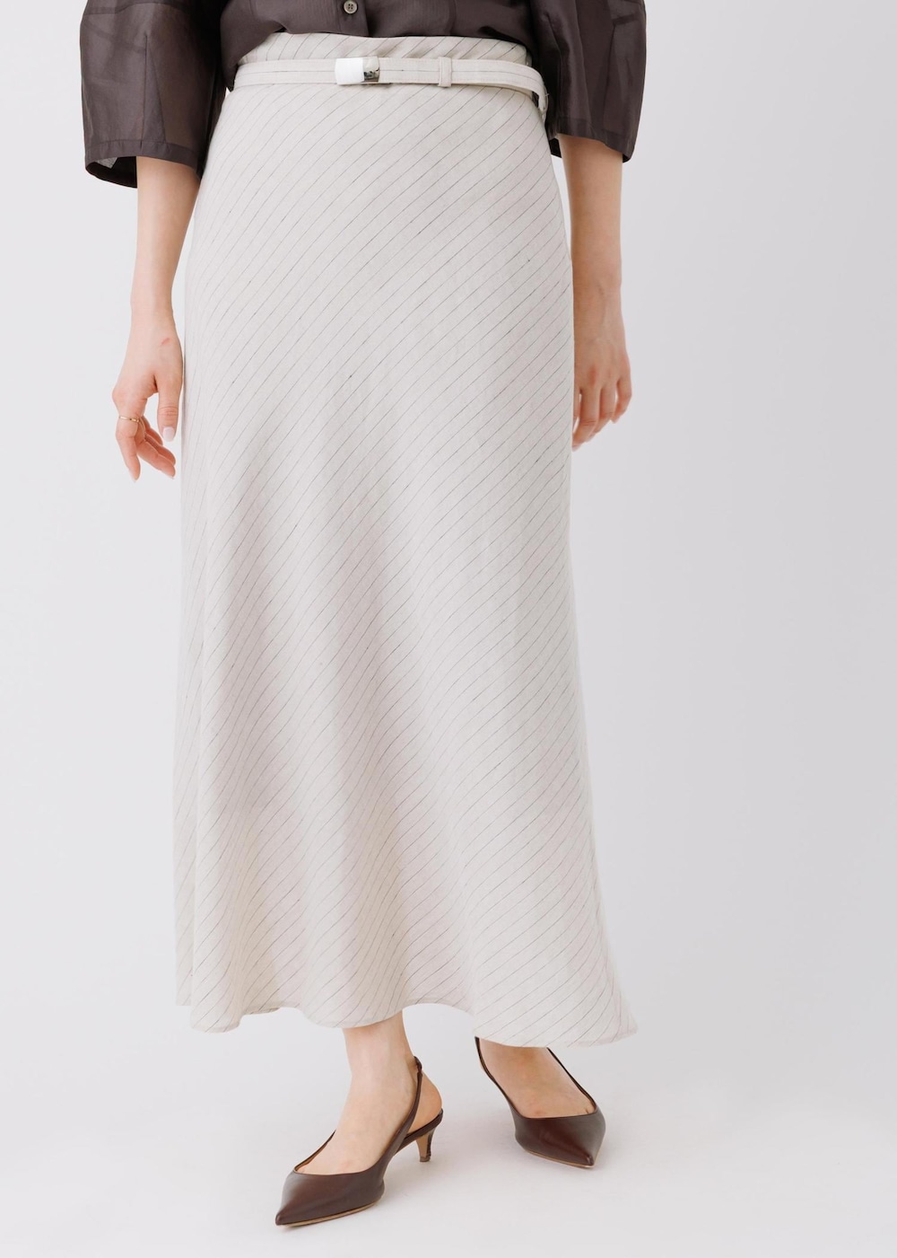 ベージュ系のスカート、ブラック系のシャツ/ブラウスを着用したレディースの春コーディネートの6枚目の写真