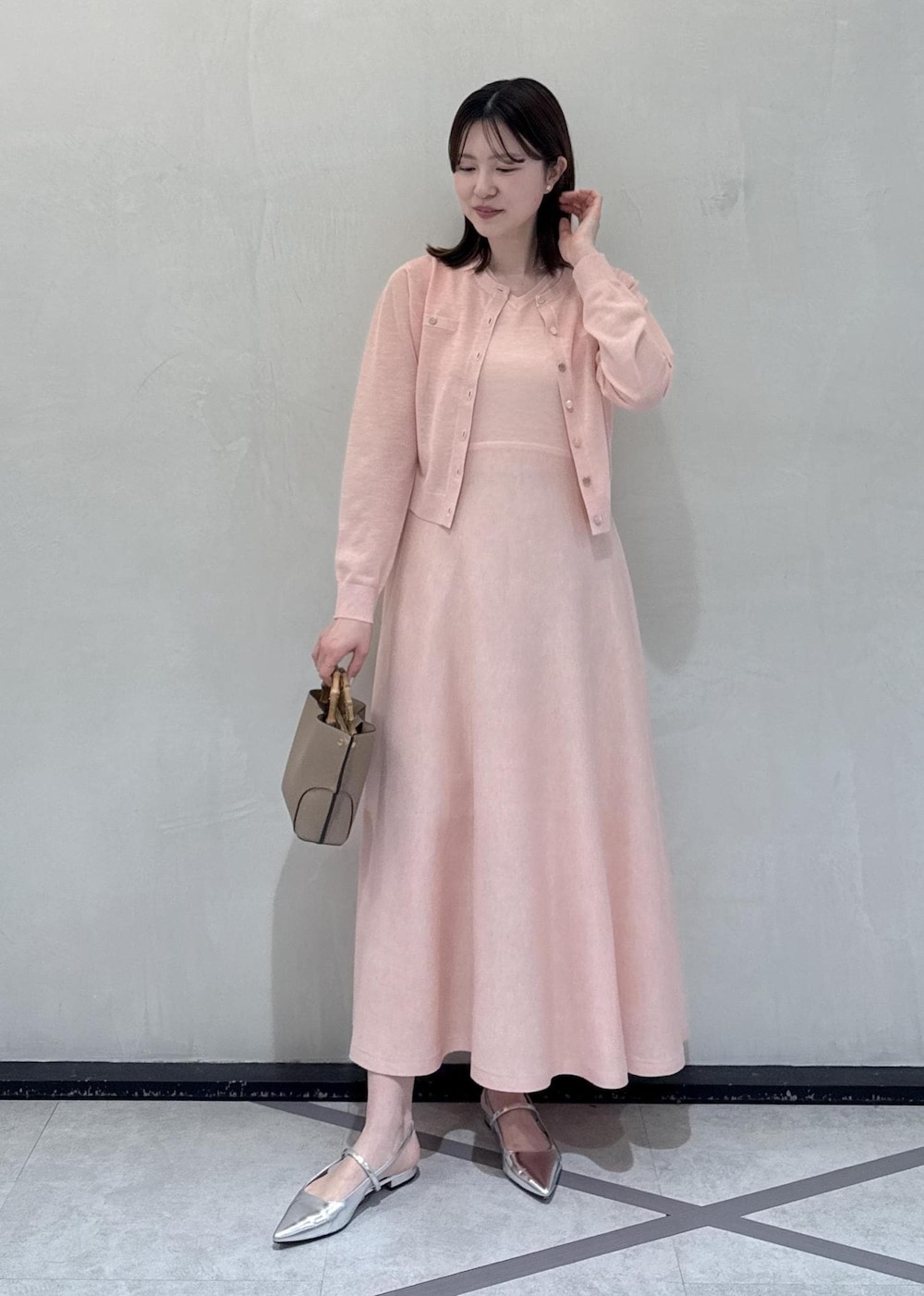 ベージュ系のハンドバッグを着用したレディースの春コーディネートの2枚目の写真