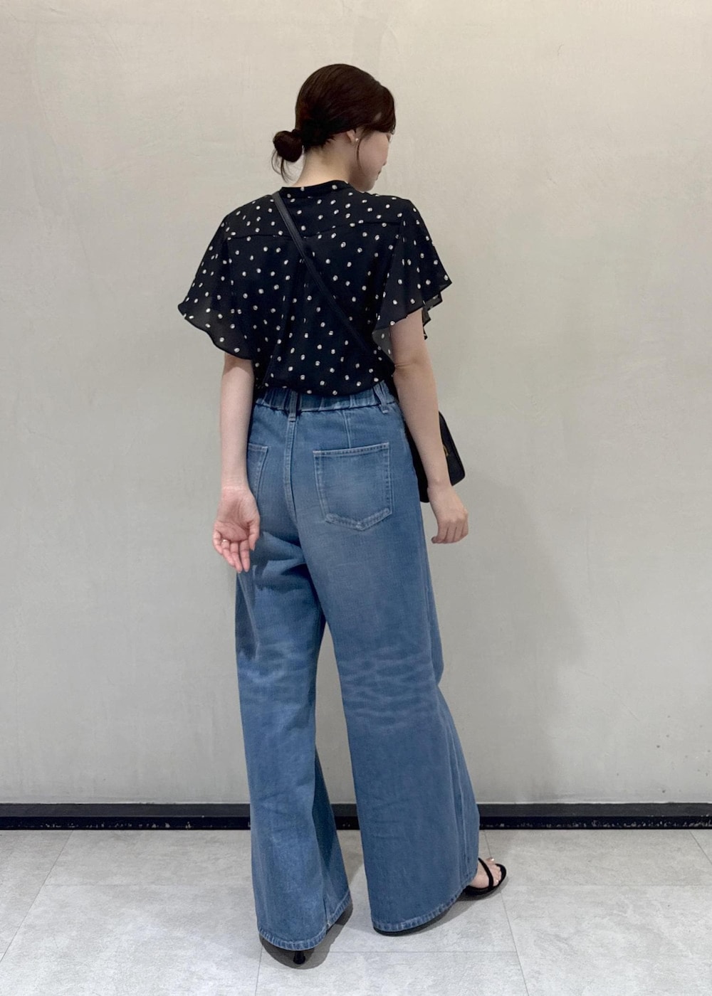ブルー系のデニムパンツ、ブラック系のシャツ/ブラウス、ブラック系のハンドバッグを着用したレディースの夏コーディネートの3枚目の写真
