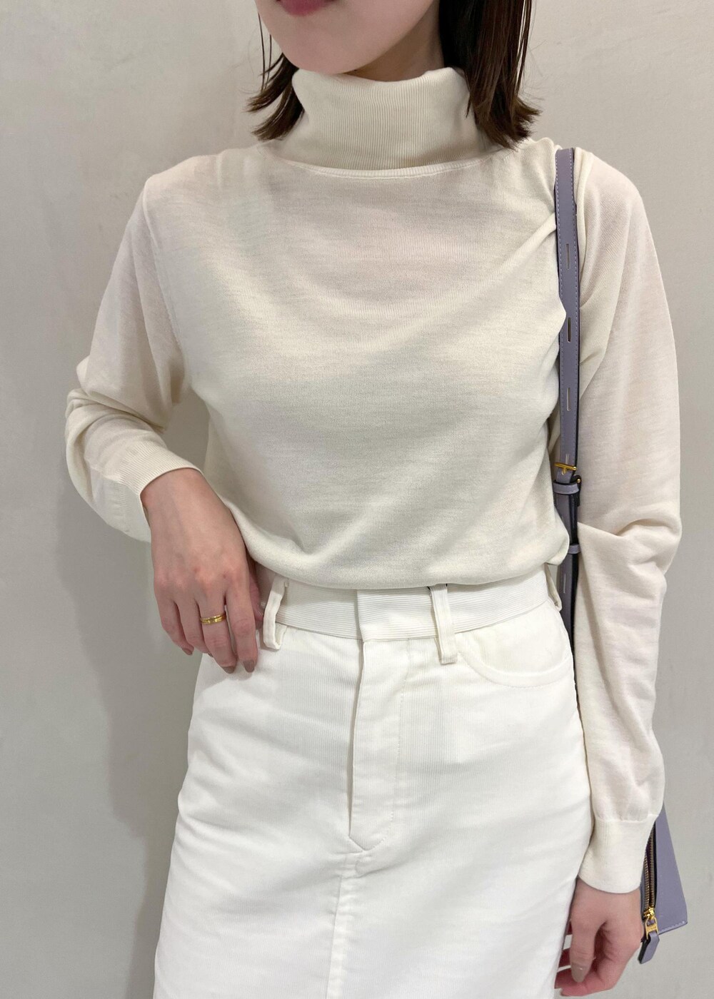 ブラック系のブーツ、ホワイト系のチェスターコート、ホワイト系のスカートを着用したレディースの秋コーディネートの6枚目の写真