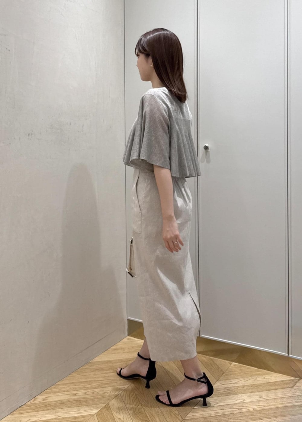 ホワイト系のハンドバッグ、ベージュ系のTシャツ/カットソー、ベージュ系のスカートを着用したレディースの夏コーディネートの2枚目の写真
