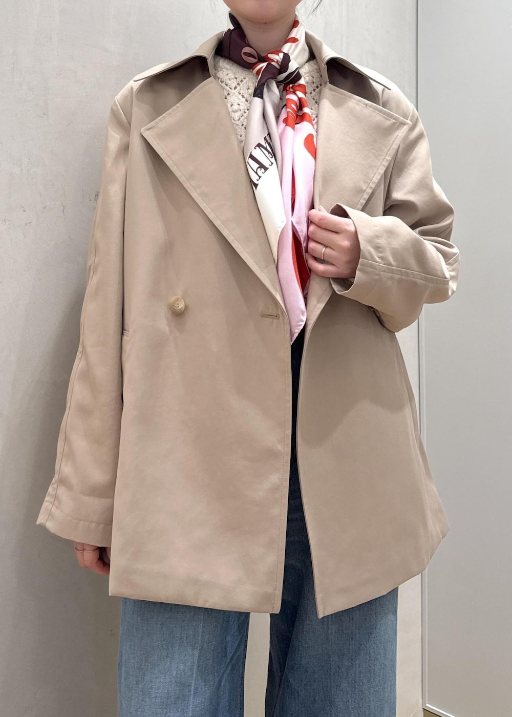 ブラック系のハンドバッグ、ホワイト系のニット/セーター、ブルー系のデニムパンツを着用したレディースの春コーディネートの5枚目の写真