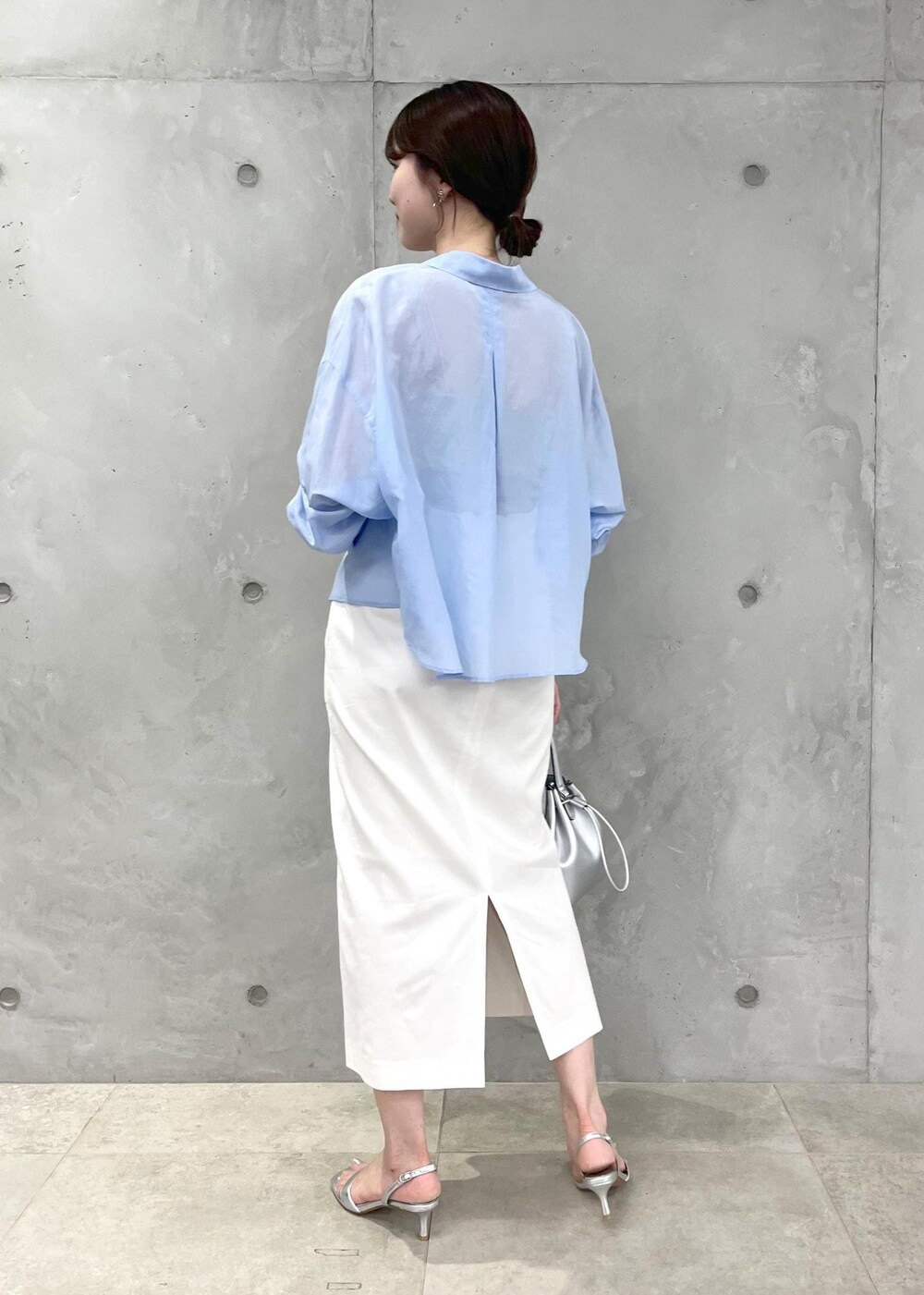 シルバー系のサンダル、ホワイト系のスカート、シルバー系のハンドバッグを着用したレディースの夏コーディネートの3枚目の写真