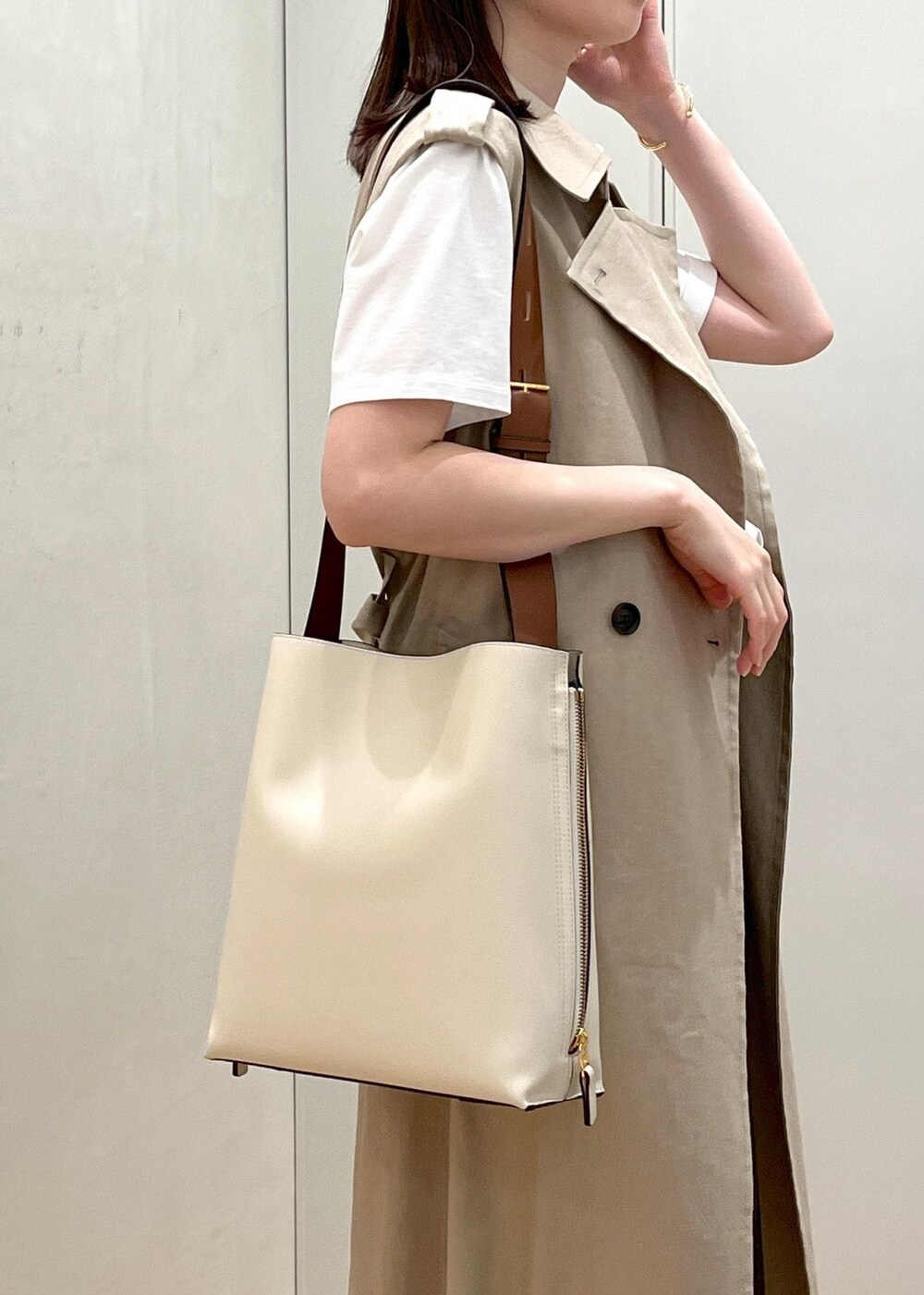 ホワイト系のサンダル、ベージュ系のベスト、ホワイト系のTシャツ/カットソーを着用したレディースの春コーディネートの4枚目の写真