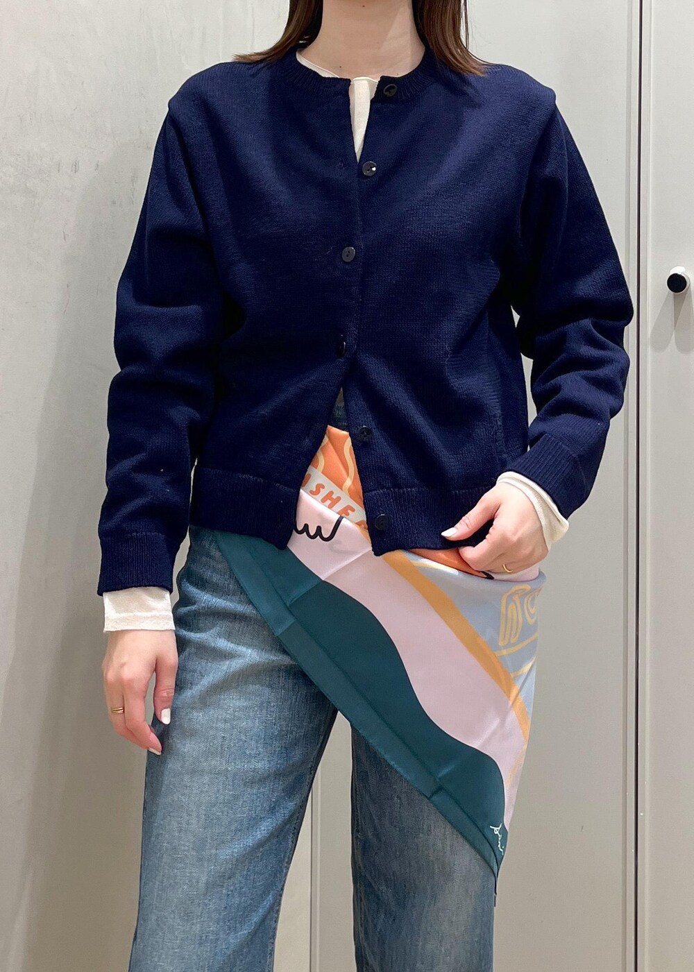 ホワイト系のハンドバッグ、シルバー系のパンプス、ブルー系のニット/セーターを着用したレディースの冬コーディネートの4枚目の写真