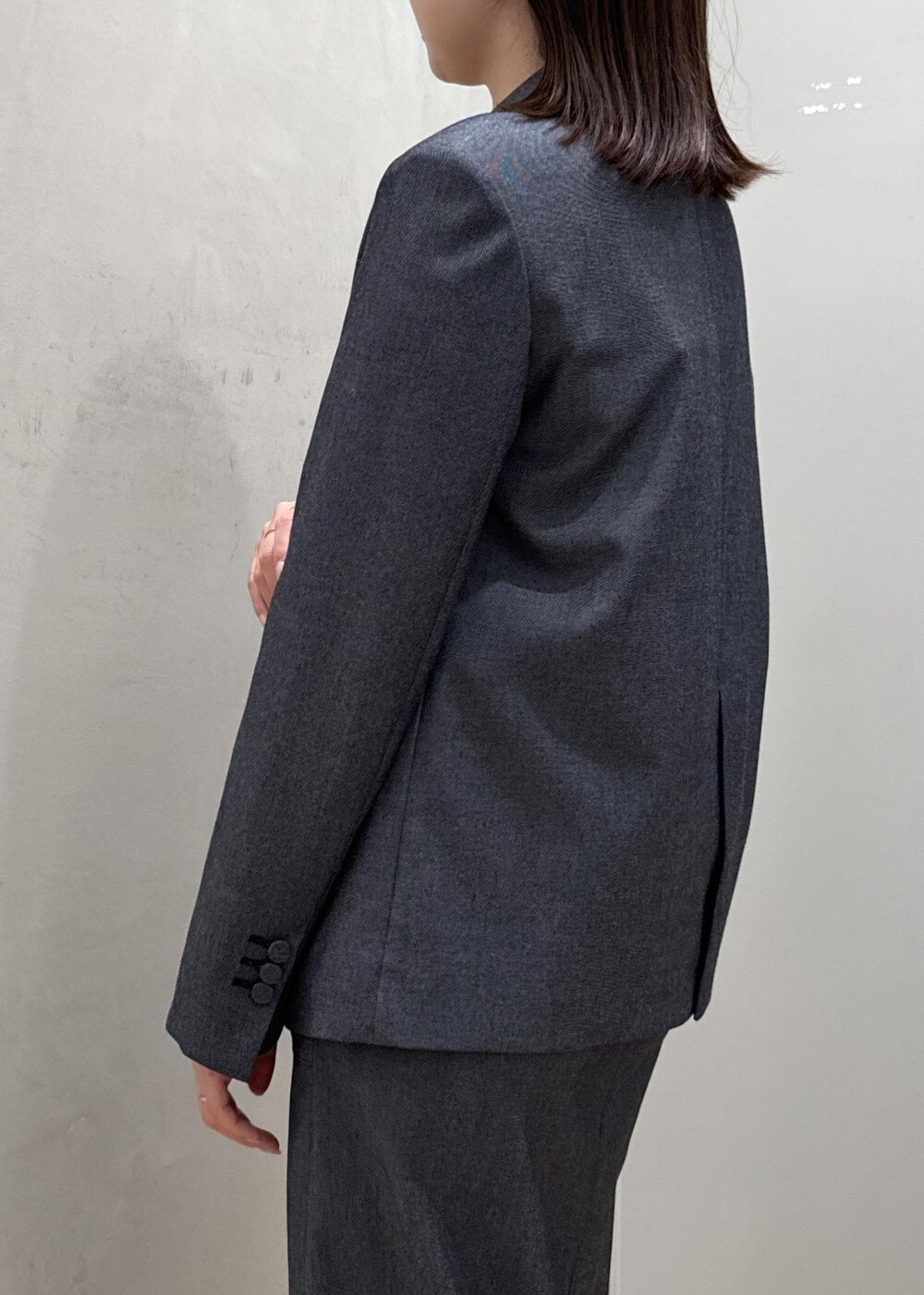 ブラック系のトートバッグ、ブルー系のテーラードジャケット、ブルー系のスカートを着用したレディースの冬コーディネートの5枚目の写真