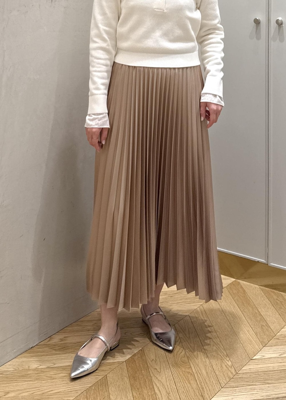 ブラック系のバックパック/リュック、ホワイト系のTシャツ/カットソー、ベージュ系のスカートを着用したレディースの春コーディネートの6枚目の写真