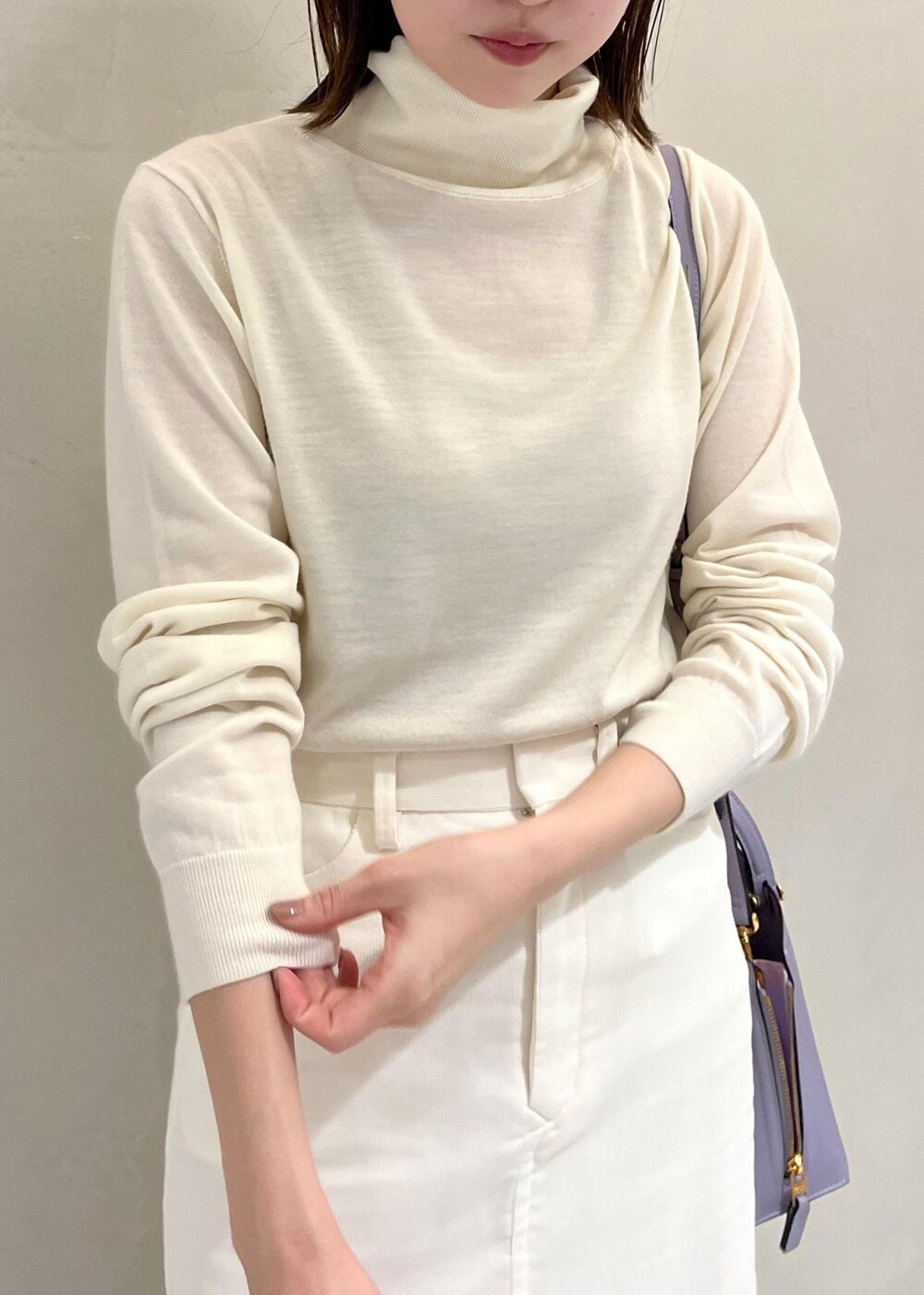 ブラック系のブーツ、ホワイト系のチェスターコート、ホワイト系のスカートを着用したレディースの秋コーディネートの7枚目の写真