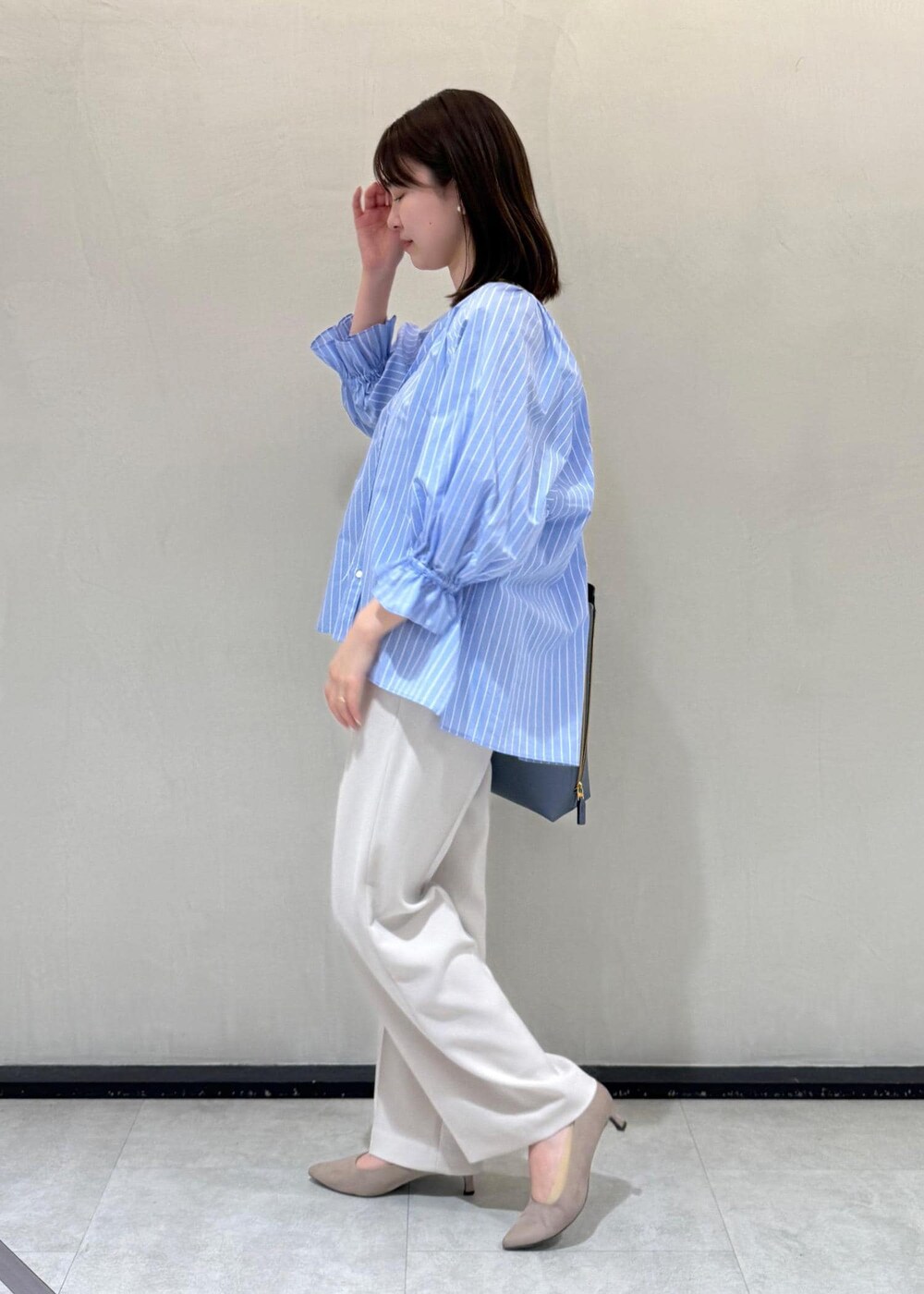 ベージュ系のその他パンツ、ブルー系のショルダーバッグ、ブルー系のシャツ/ブラウスを着用したレディースの春コーディネートの2枚目の写真