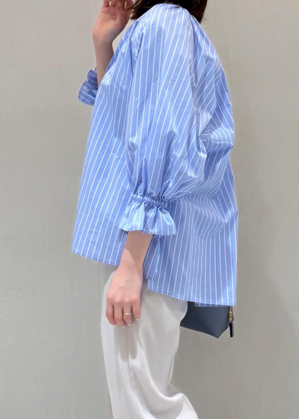 ベージュ系のその他パンツ、ブルー系のショルダーバッグ、ブルー系のシャツ/ブラウスを着用したレディースの春コーディネートの5枚目の写真