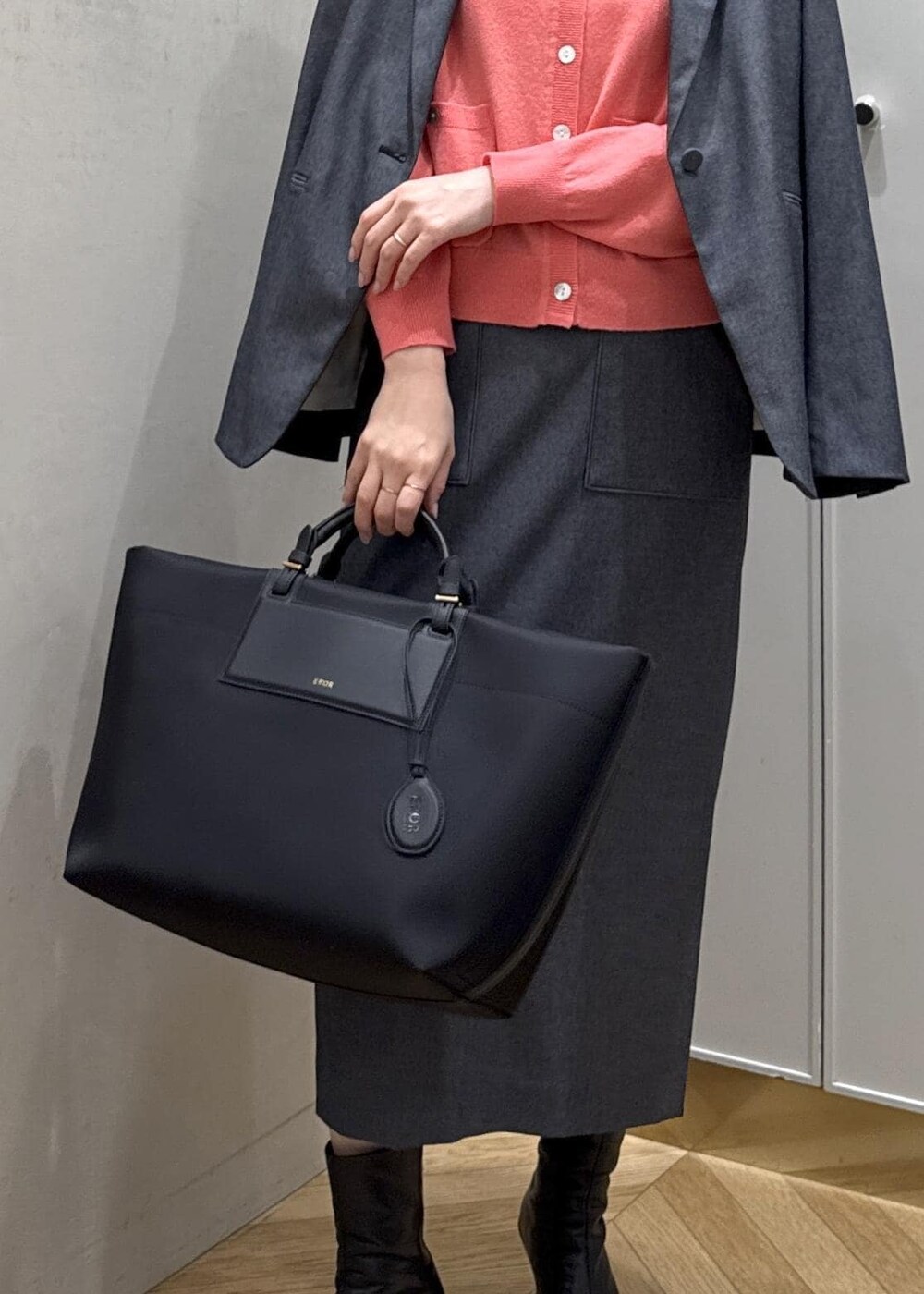 ブラック系のトートバッグ、ブルー系のテーラードジャケット、ブルー系のスカートを着用したレディースの冬コーディネートの9枚目の写真