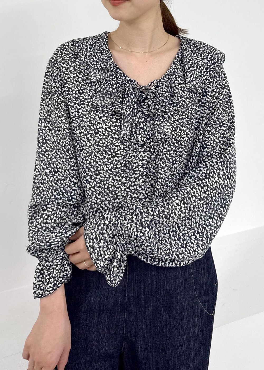 グレー系のハンドバッグ、ブラウン系のブーツ、ブルー系のデニムパンツを着用したレディースの秋コーディネートの5枚目の写真