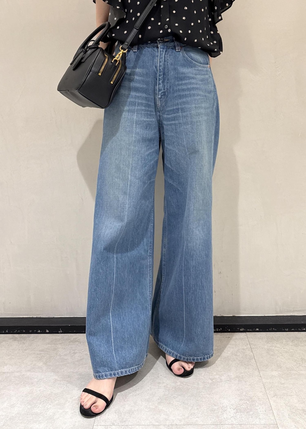 ブルー系のデニムパンツ、ブラック系のシャツ/ブラウス、ブラック系のハンドバッグを着用したレディースの夏コーディネートの7枚目の写真