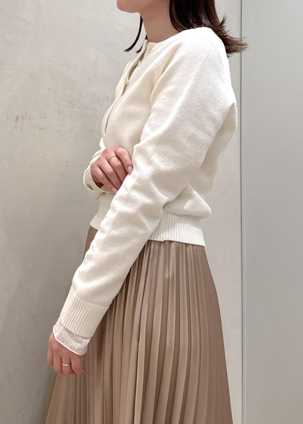 ブラック系のバックパック/リュック、ホワイト系のTシャツ/カットソー、ベージュ系のスカートを着用したレディースの春コーディネートの5枚目の写真