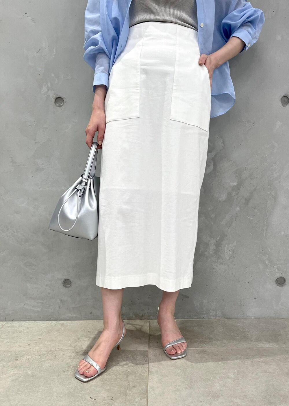 シルバー系のサンダル、ホワイト系のスカート、シルバー系のハンドバッグを着用したレディースの夏コーディネートの6枚目の写真