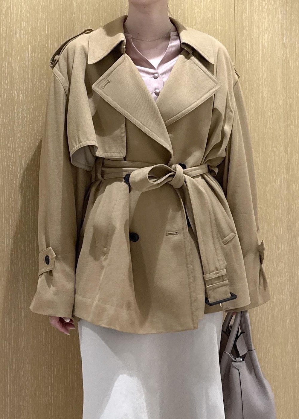 ベージュ系のトレンチコート、ベージュ系のスカート、ピンク系のシャツ/ブラウスを着用したレディースの春コーディネートの4枚目の写真