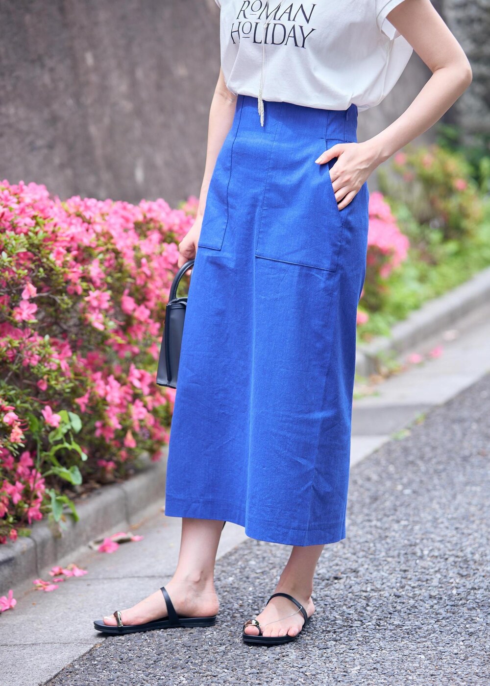 グレー系のショルダーバッグ、ブラック系のサンダル、ブルー系のスカートを着用したレディースの夏コーディネートの7枚目の写真