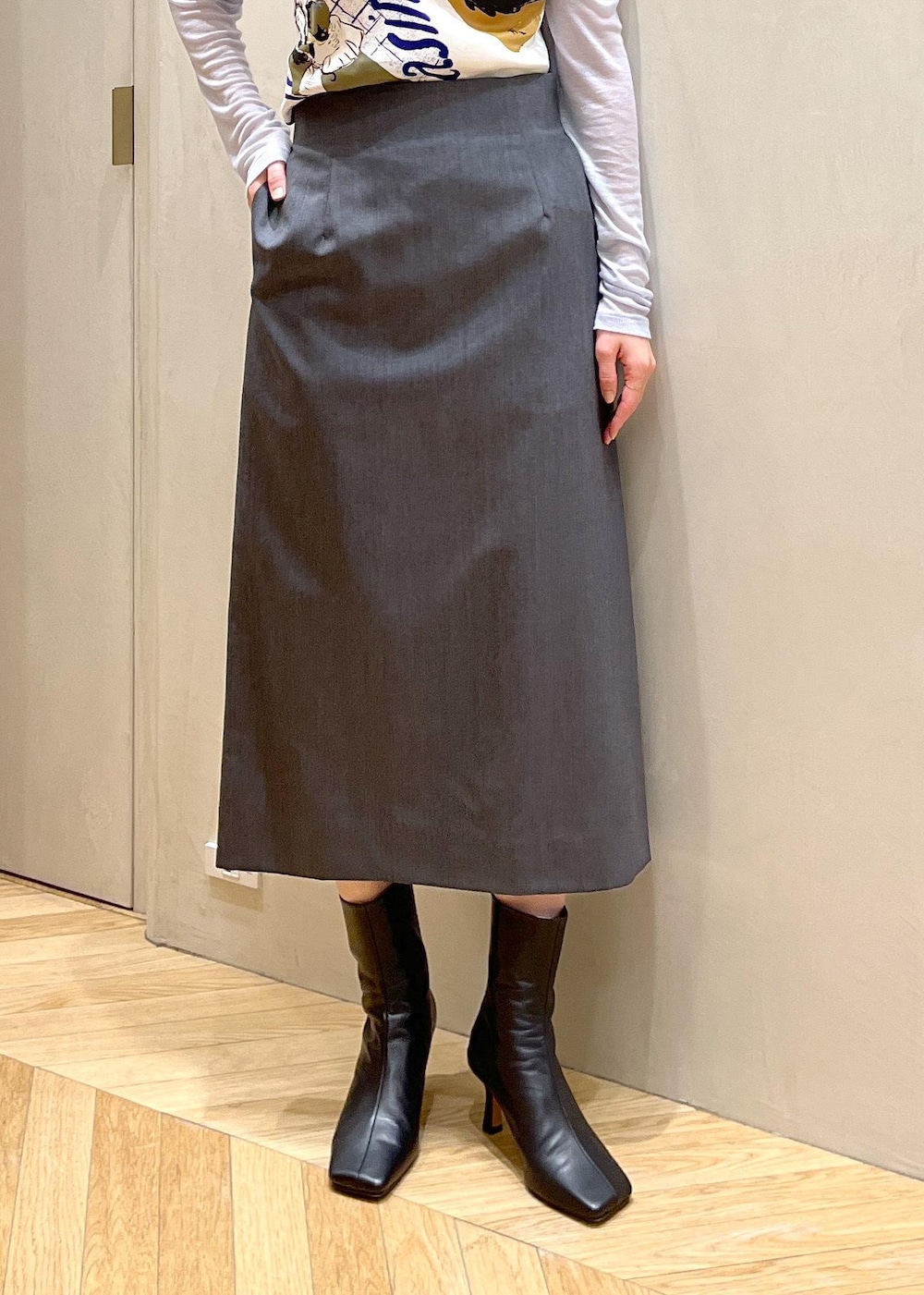 ブラック系のブーツ、ブルー系のショルダーバッグ、グレー系のベストを着用したレディースの秋コーディネートの5枚目の写真