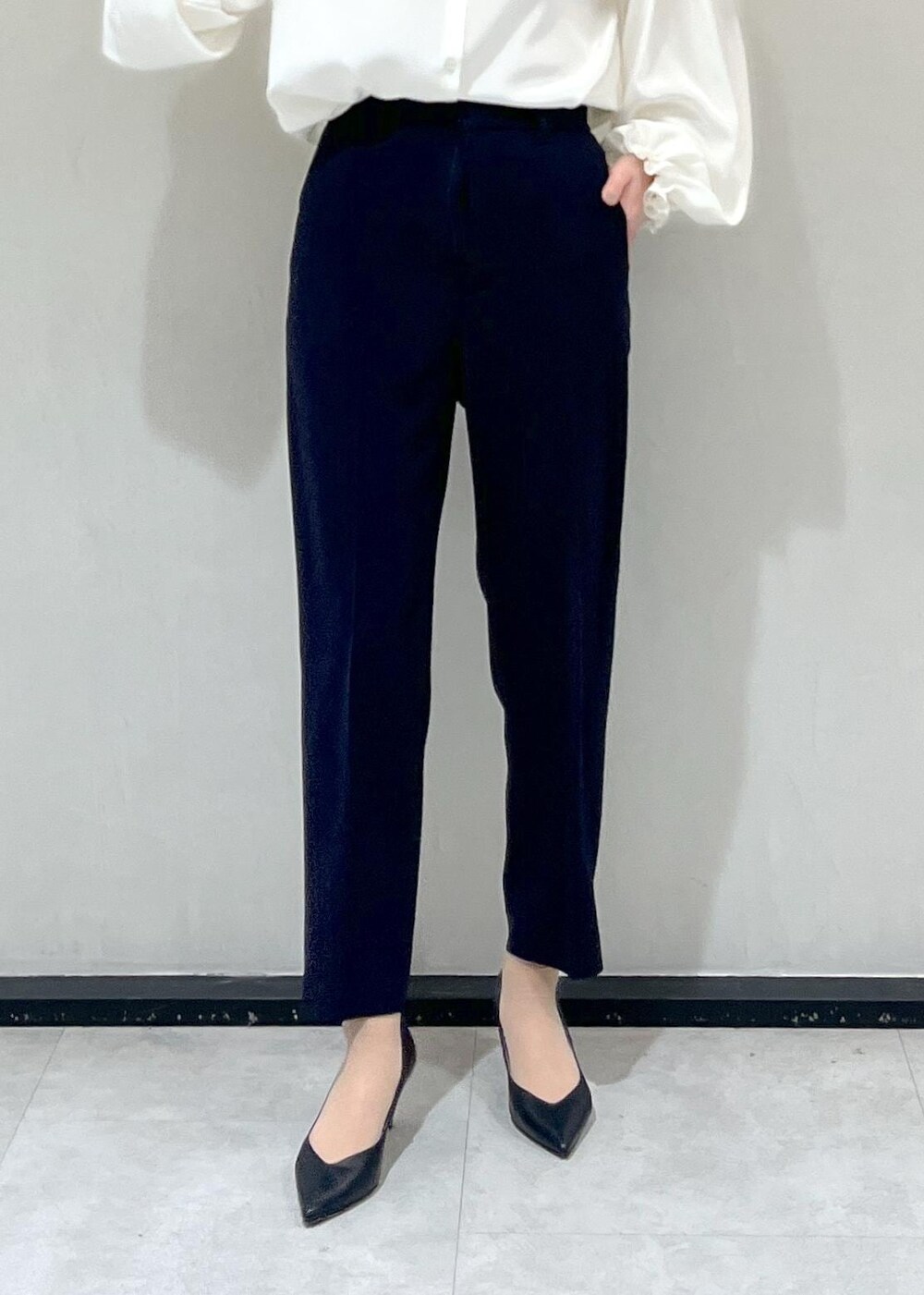 ブラック系のパンプス、ブラック系のハンドバッグ、ホワイト系のシャツ/ブラウスを着用したレディースの冬コーディネートの7枚目の写真