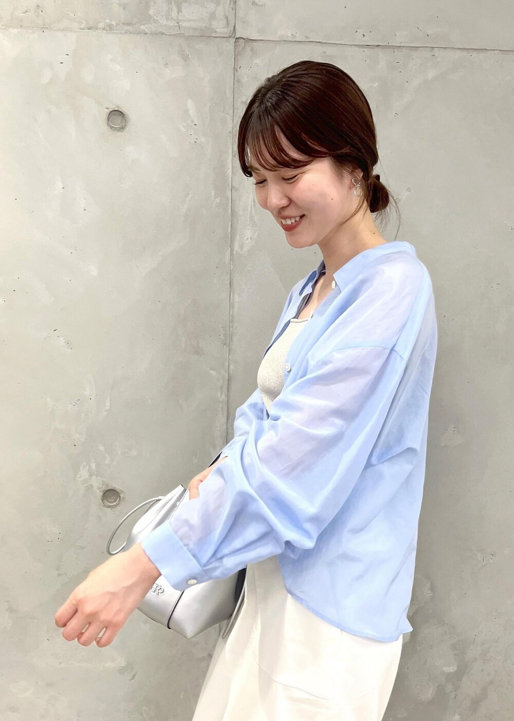 シルバー系のサンダル、ホワイト系のスカート、シルバー系のハンドバッグを着用したレディースの夏コーディネートの5枚目の写真