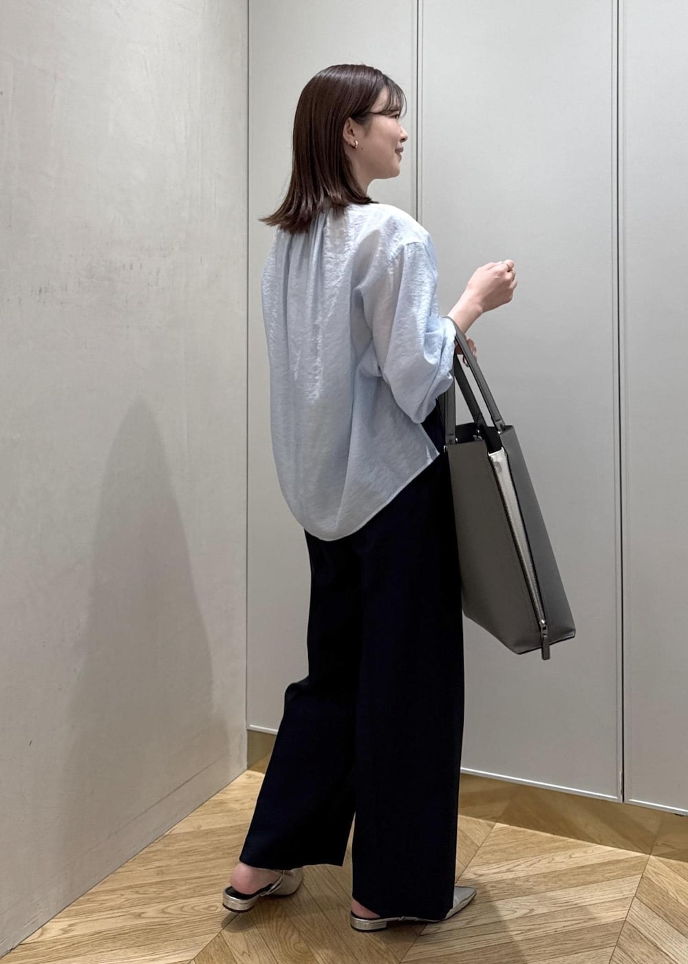 グレー系のトートバッグ、ブルー系のその他パンツ、ブルー系のシャツ/ブラウスを着用したレディースの春コーディネートの3枚目の写真