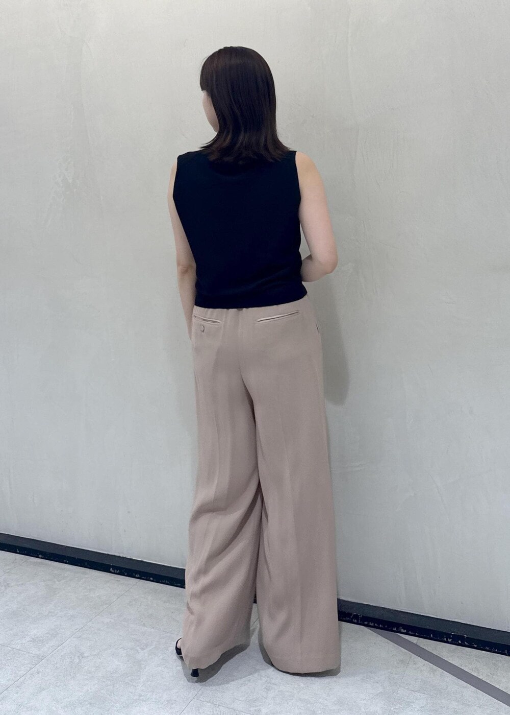 ベージュ系のトートバッグ、ベージュ系のその他パンツ、ブラック系のTシャツ/カットソーを着用したレディースの春コーディネートの5枚目の写真