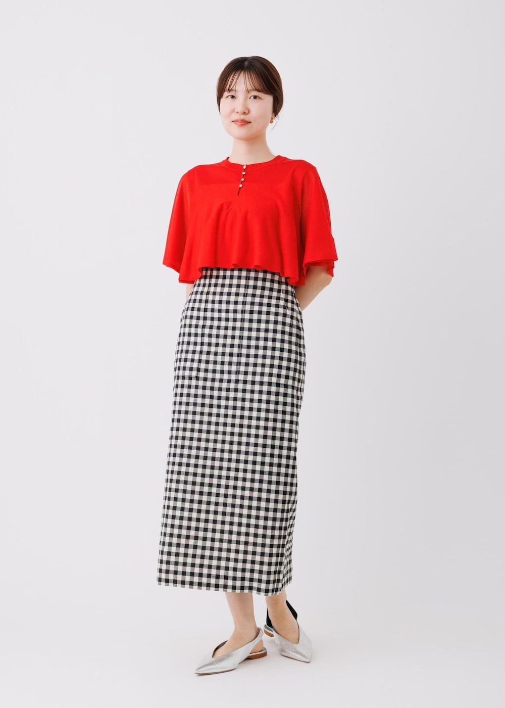 レッド系のTシャツ/カットソー、ブラック系のスカートを着用したレディースの春コーディネートの2枚目の写真