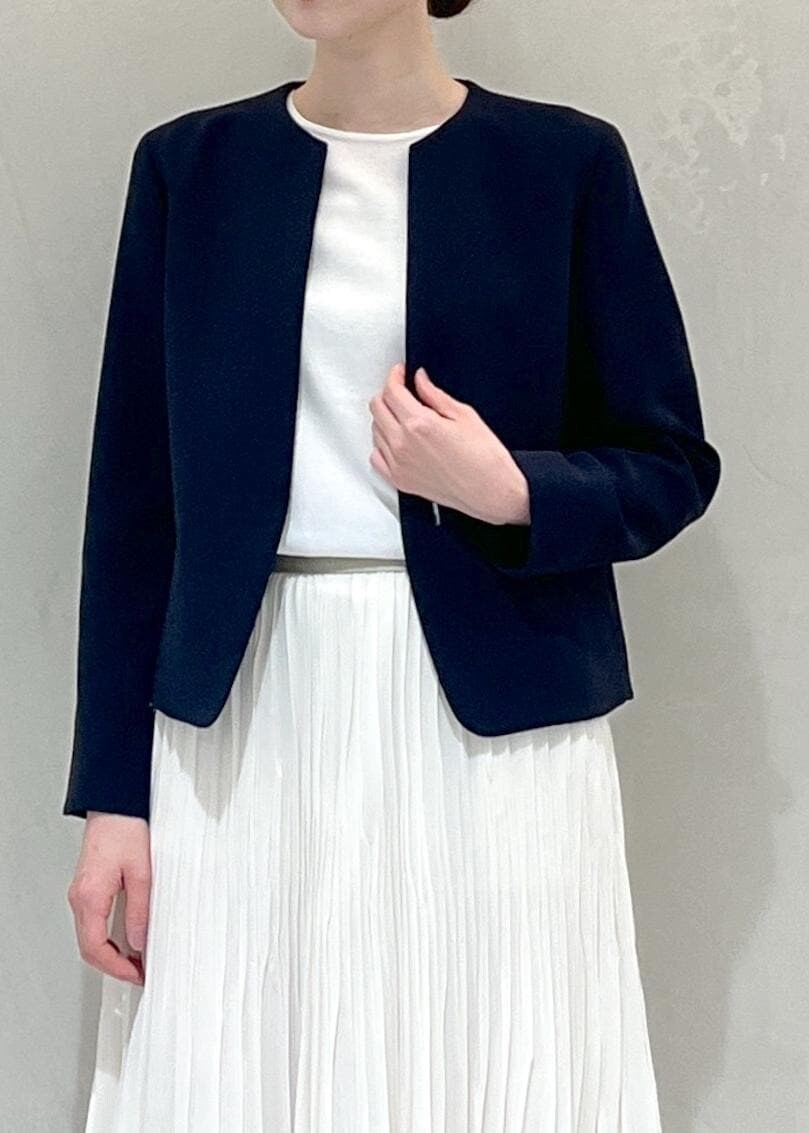 ブラック系のパンプス、ブルー系のノーカラージャケット、ホワイト系のスカートを着用したレディースの冬コーディネートの4枚目の写真