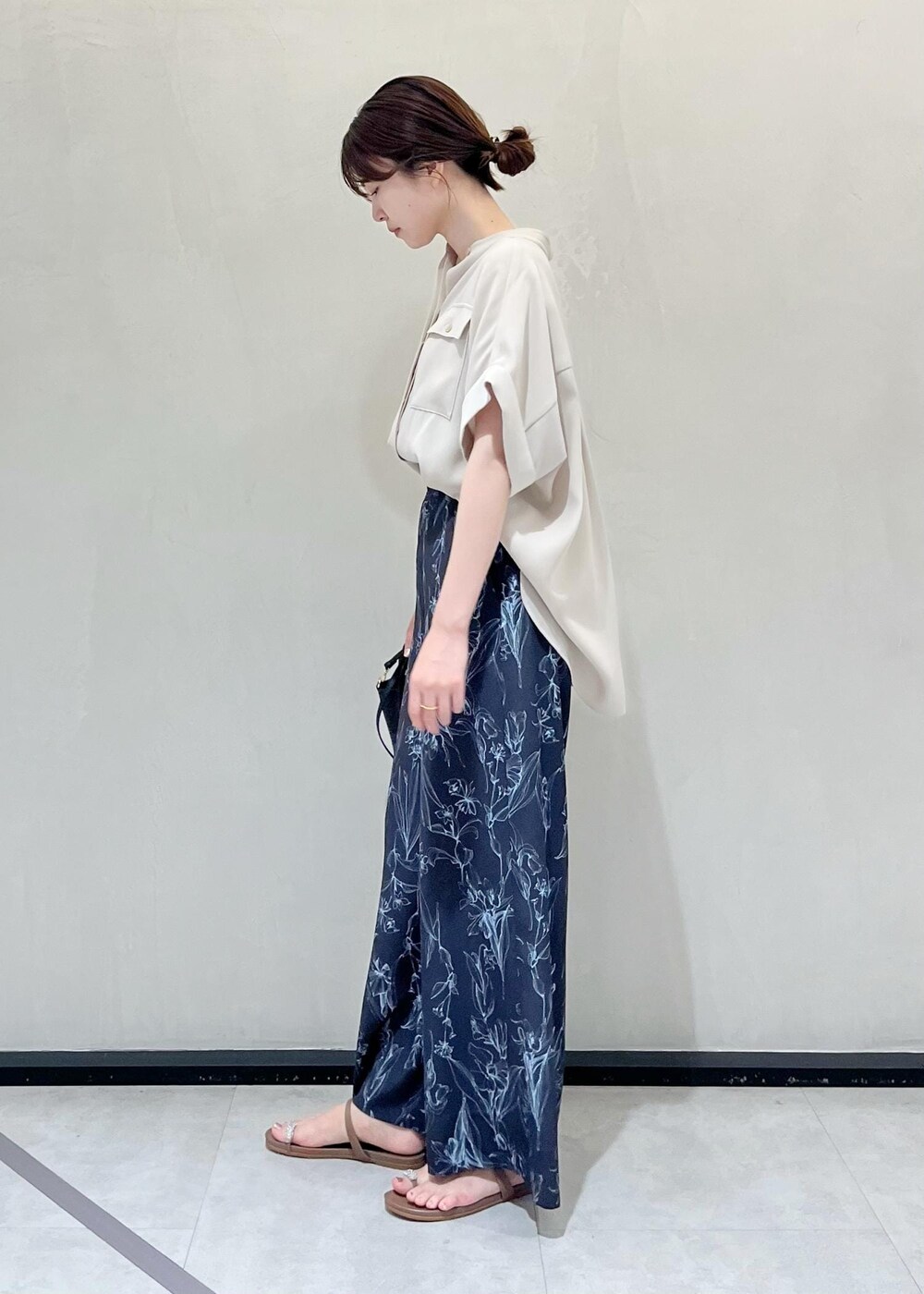 ブラック系のハンドバッグ、ベージュ系のサンダル、ベージュ系のシャツ/ブラウスを着用したレディースの夏コーディネートの2枚目の写真