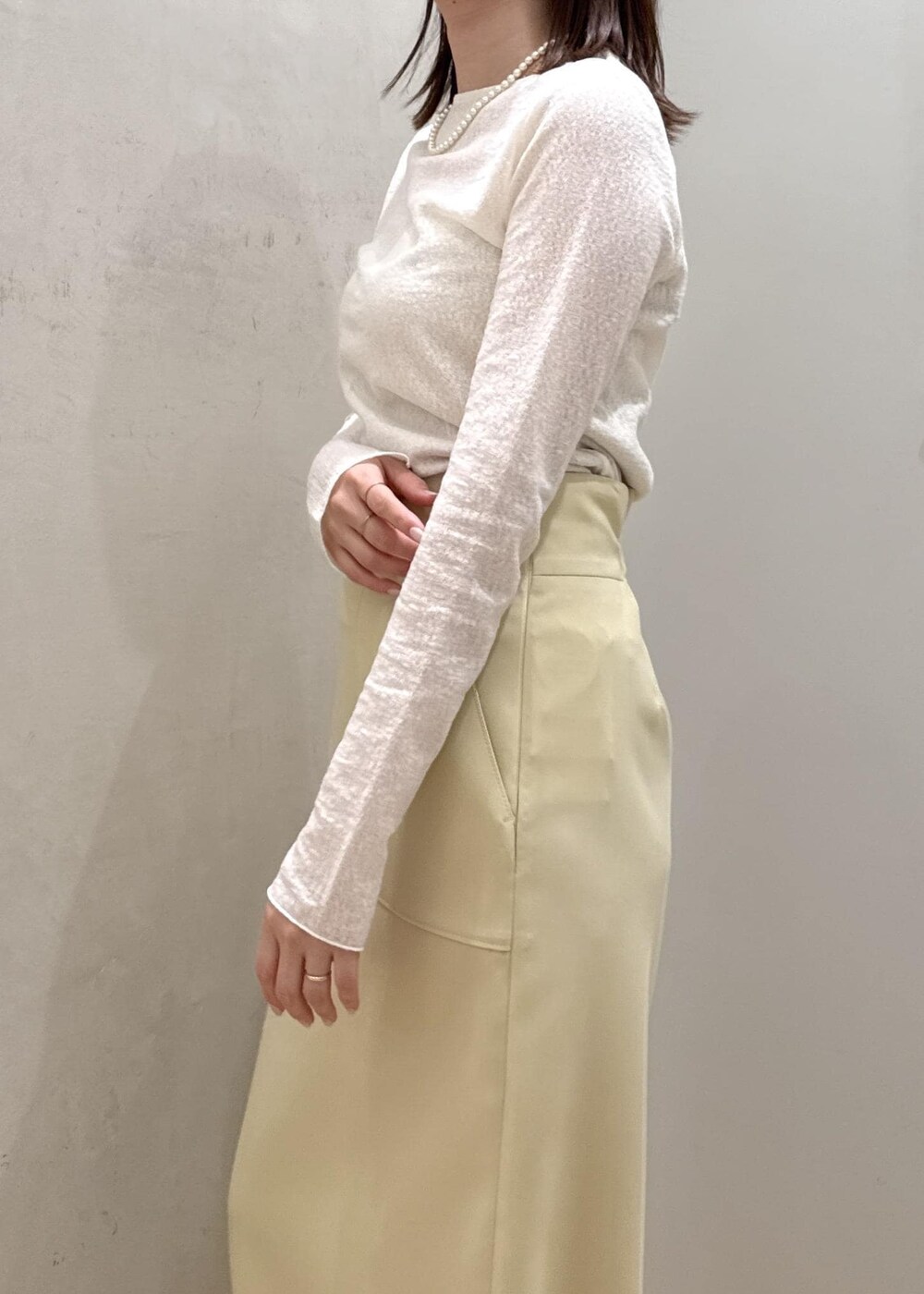 ベージュ系のショルダーバッグ、イエロー系のスカート、ブルー系のデニムジャケットを着用したレディースの春コーディネートの7枚目の写真