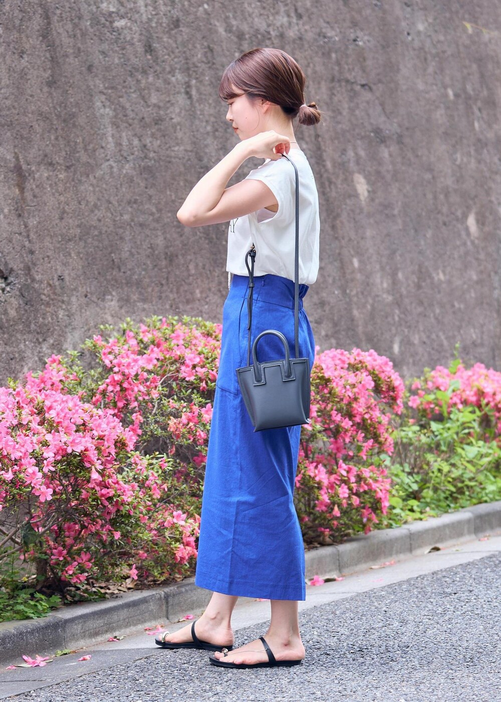 グレー系のショルダーバッグ、ブラック系のサンダル、ブルー系のスカートを着用したレディースの夏コーディネートの3枚目の写真