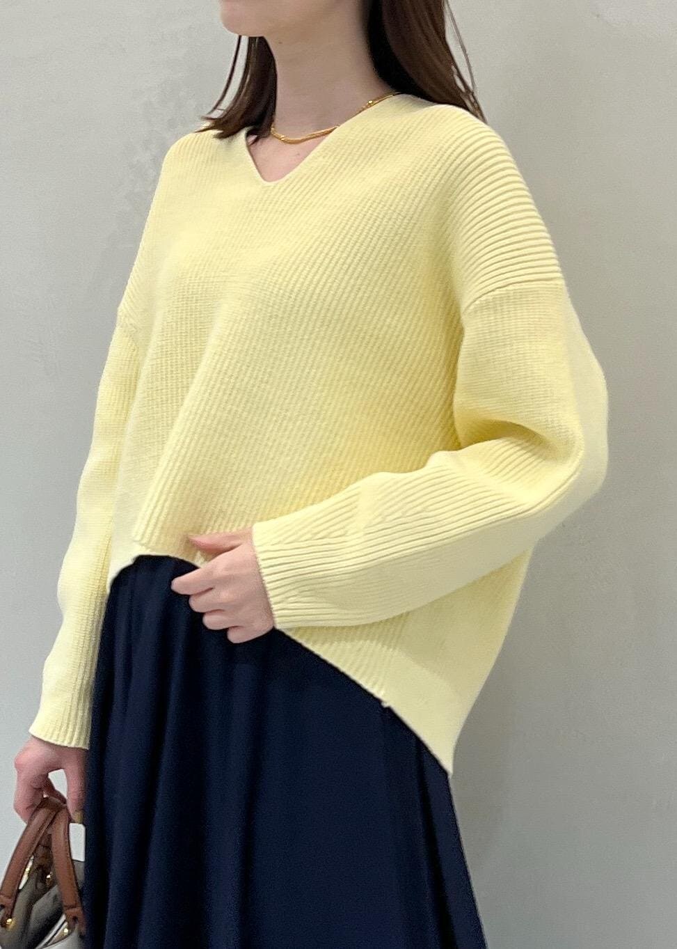 ホワイト系のハンドバッグ、ホワイト系のブーツ、ブルー系のスカートを着用したレディースの冬コーディネートの4枚目の写真