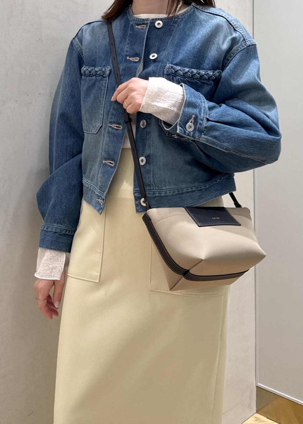 ベージュ系のショルダーバッグ、イエロー系のスカート、ブルー系のデニムジャケットを着用したレディースの春コーディネートの10枚目の写真