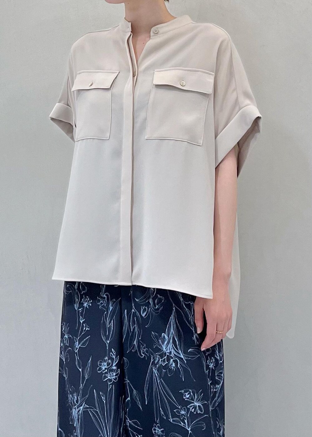 ブラック系のハンドバッグ、ベージュ系のサンダル、ベージュ系のシャツ/ブラウスを着用したレディースの夏コーディネートの4枚目の写真