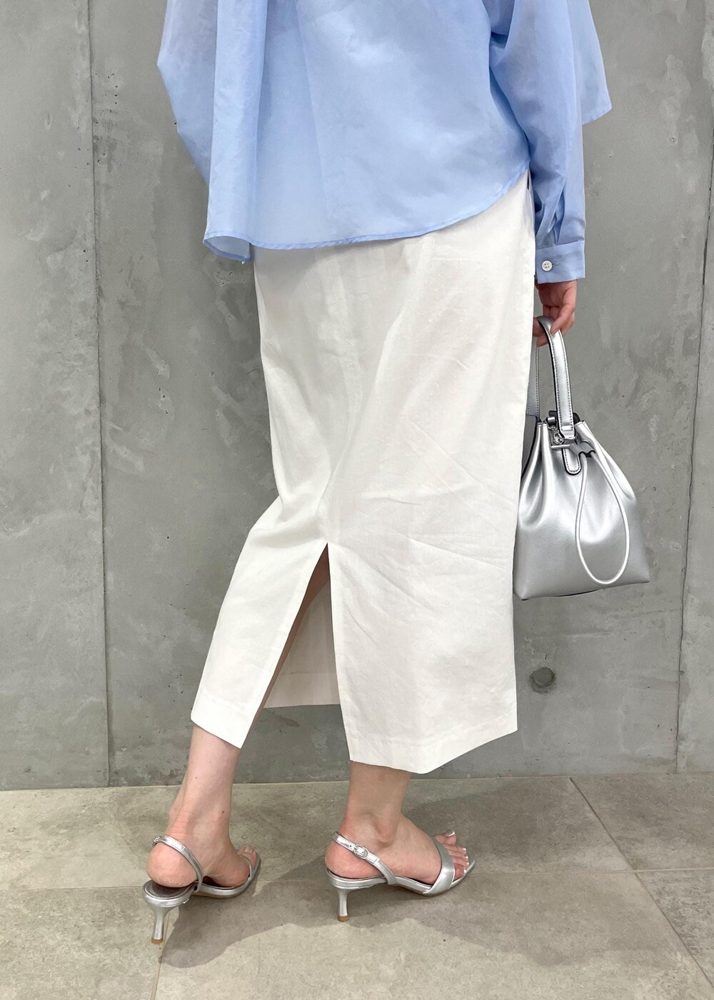 シルバー系のサンダル、ホワイト系のスカート、シルバー系のハンドバッグを着用したレディースの夏コーディネートの7枚目の写真