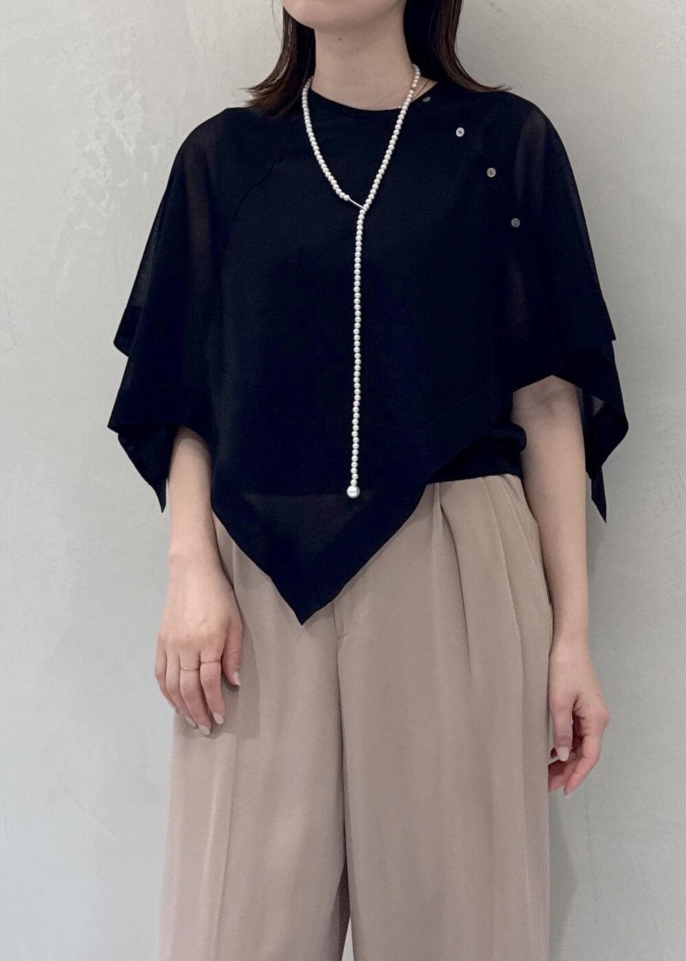 ベージュ系のトートバッグ、ベージュ系のその他パンツ、ブラック系のTシャツ/カットソーを着用したレディースの春コーディネートの6枚目の写真