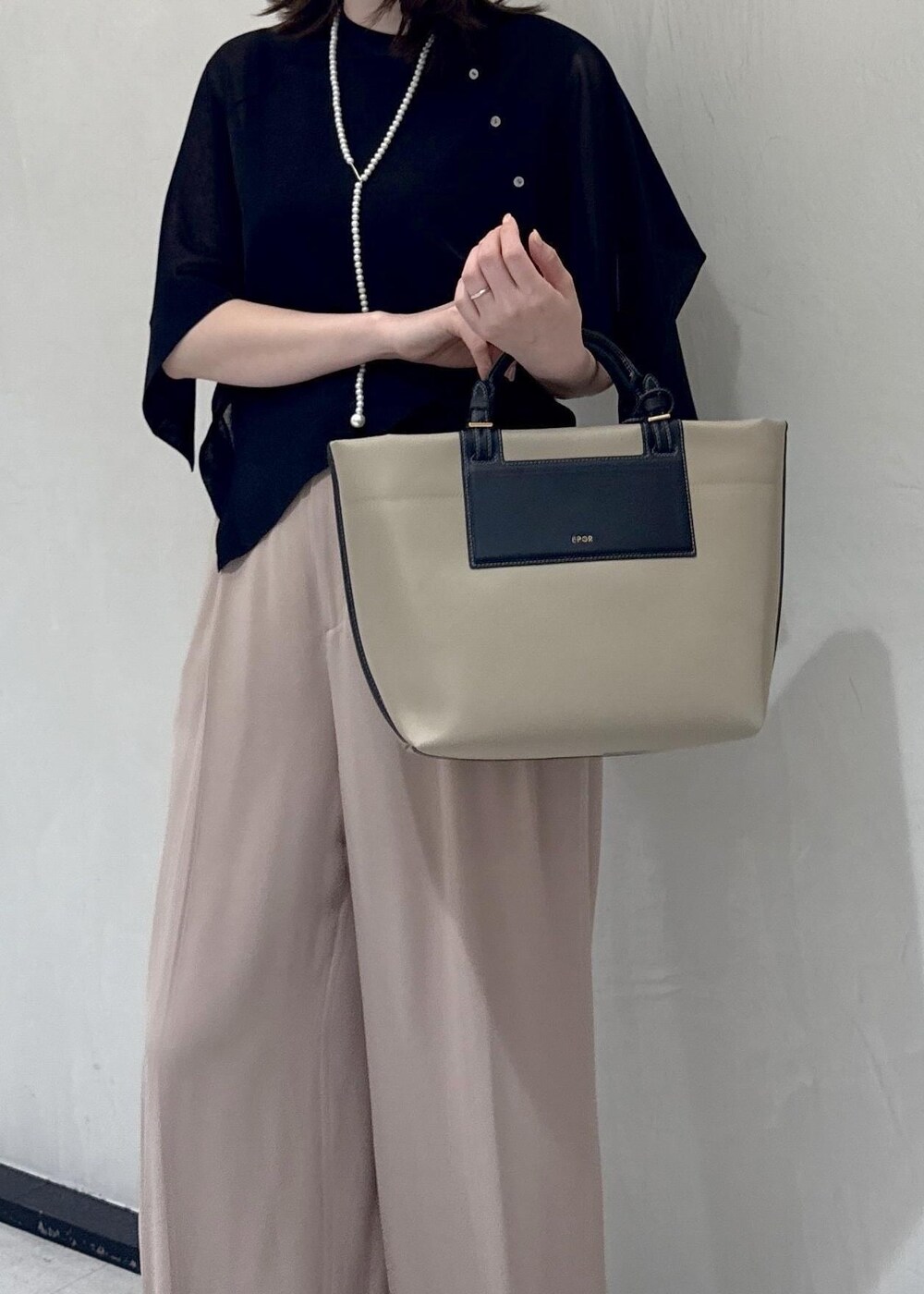 ベージュ系のトートバッグ、ベージュ系のその他パンツ、ブラック系のTシャツ/カットソーを着用したレディースの春コーディネートの10枚目の写真