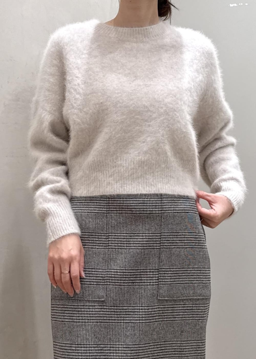 ブラウン系のブーツ、ブラウン系のハンドバッグ、ホワイト系のステンカラーコートを着用したレディースの秋コーディネートの4枚目の写真