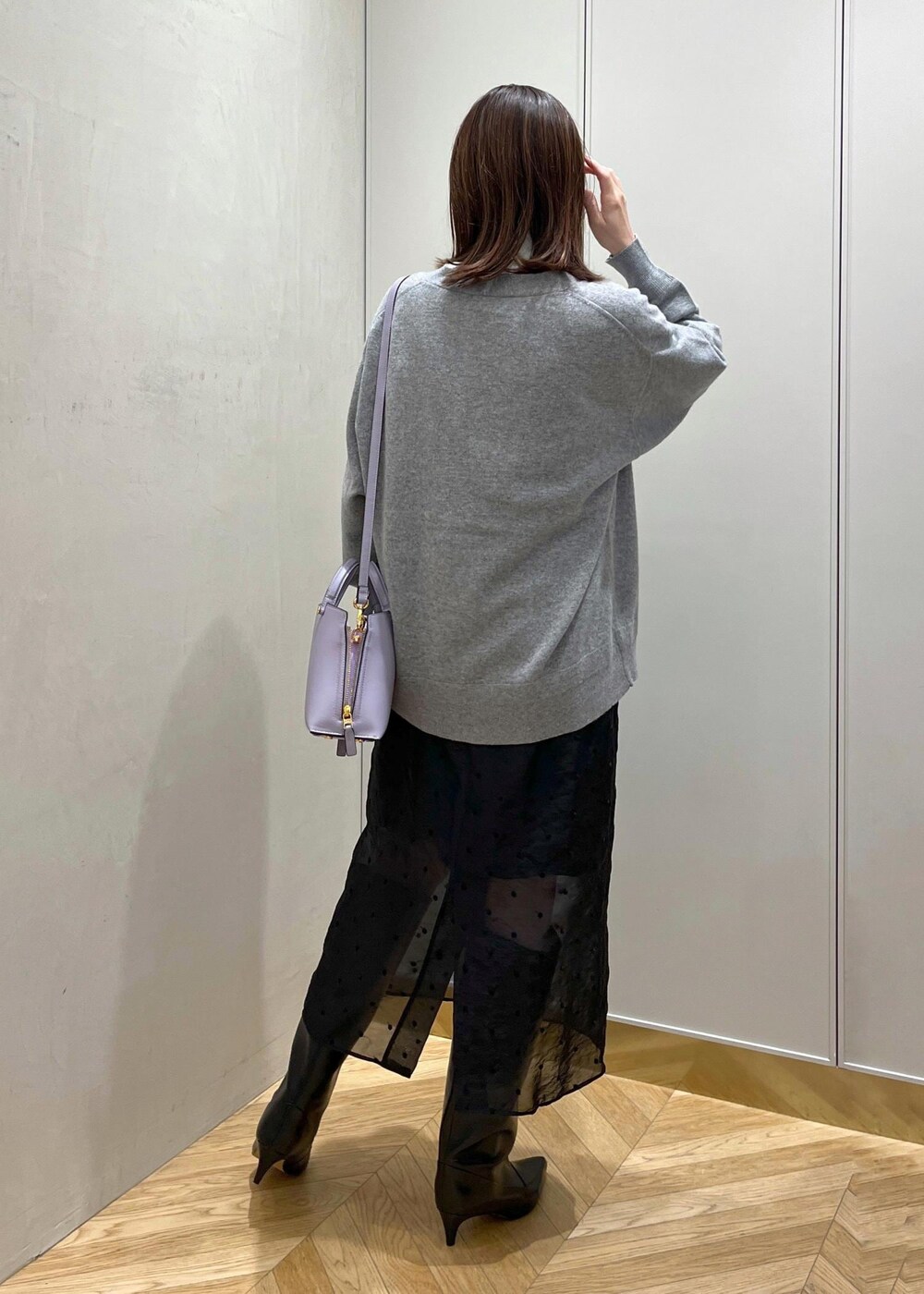 ブラック系のブーツ、ホワイト系のシャツ/ブラウス、グレー系のカーディガン/ボレロを着用したレディースの秋コーディネートの4枚目の写真